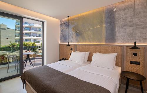 ein Schlafzimmer mit einem großen Bett und einem Balkon in der Unterkunft Leonidas Hotel & Apartments in Rethymno