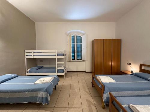 a room with three beds and a window at San Giuseppe Casa per Ferie in Quercianella