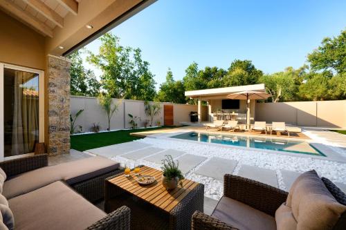 a backyard with a swimming pool and a patio at Villa Idola Dassia Corfu in Dassia