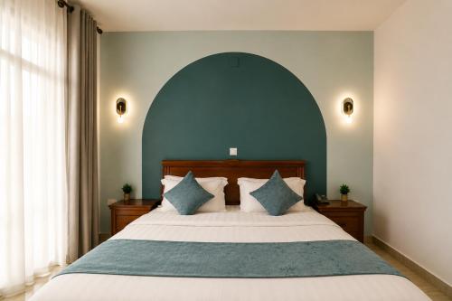 a bedroom with a large bed with a blue wall at Highlands Suites Hotel and Apartments in Kigali