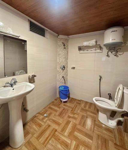 a bathroom with two sinks and a toilet in it at Lecoxy Resort in Lachung