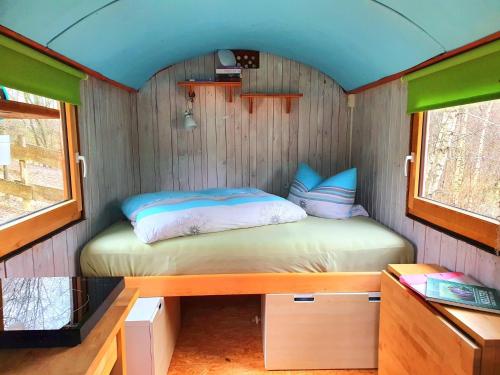 a small bedroom with a bed in a tiny house at LandAuszeit Hummeltal in Culm
