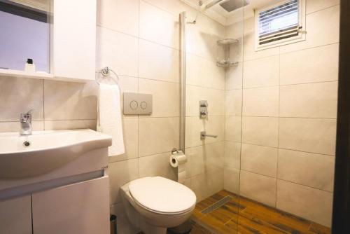 a white bathroom with a toilet and a sink at İSKALİTA Otel in Altındere