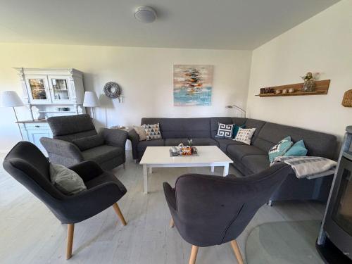a living room with a couch and chairs and a table at Landhaus Scholz in Dollerup