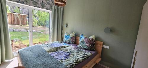 a bed in a room with a window at Gartenbungalow Rhönwild in Hilders
