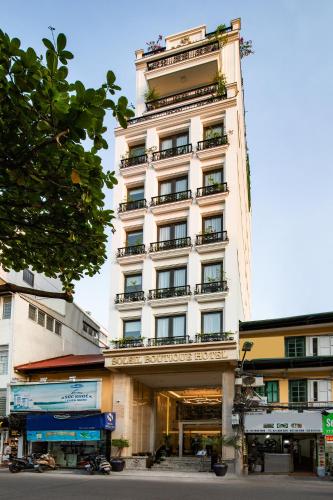 a tall white building with balconies on it at Soleil Boutique Hotel Hanoi in Hanoi