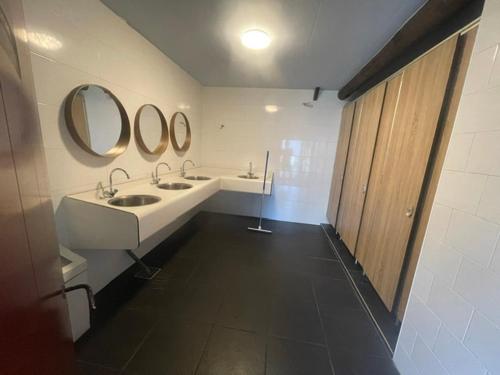 a bathroom with two sinks and two mirrors at Safaritent in Kolham
