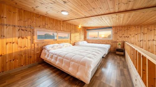 a large bed in a room with wooden walls at boryeong hiddenvillage dokchae poolvilla in Boryeong