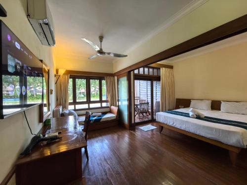 a bedroom with a bed and a couch and a table at Langkawi Lagoon Floating Resort 03 in Kampung Padang Masirat
