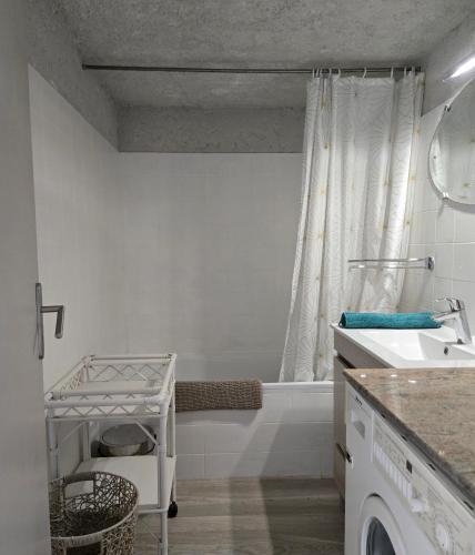 a white bathroom with a sink and a tub at Laure Cabasson in Bormes-les-Mimosas