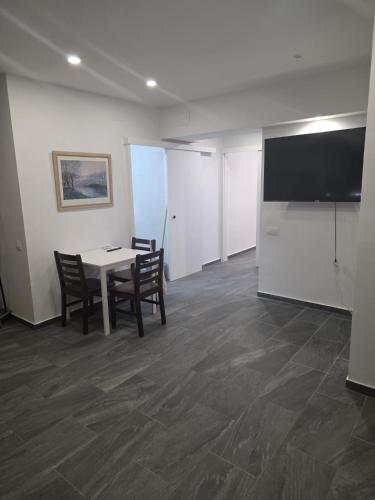 a room with a table and chairs and a flat screen tv at Apartamento Centro in Rubí