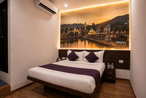 a bedroom with a bed with a painting on the wall at Hotel Dwarka Executive in Nashik