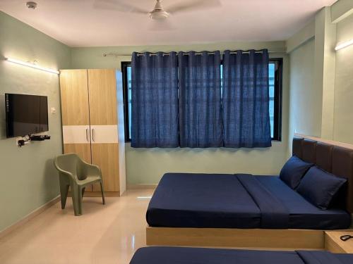 a bedroom with a blue bed and a television at FabHotel Metro Stay in Kolkata