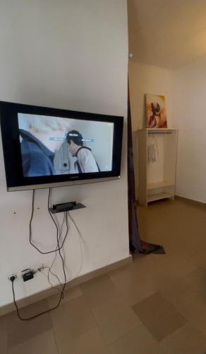 a flat screen tv hanging on a wall at Bk House in Pointe-Noire