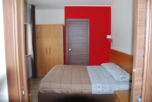 1 dormitorio con cama y pared roja en Guest House Caracas en Lorica