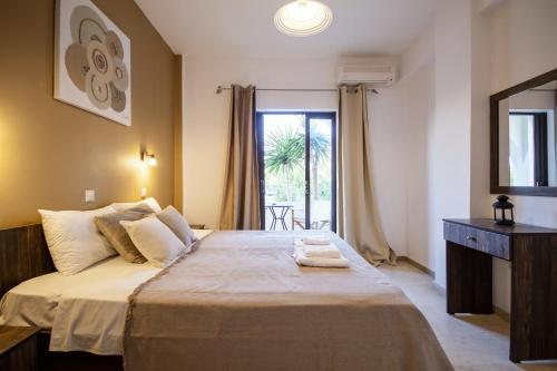 a bedroom with a large bed and a window at Mariposa Apartments in Kavos