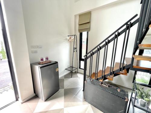 a room with a staircase and a small refrigerator at Milky house in Ban Bang Phai
