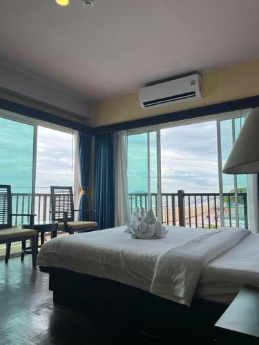 a bedroom with a bed with a view of the ocean at Sarita Chalet & Spa Jomtien beach Pattaya in Jomtien Beach