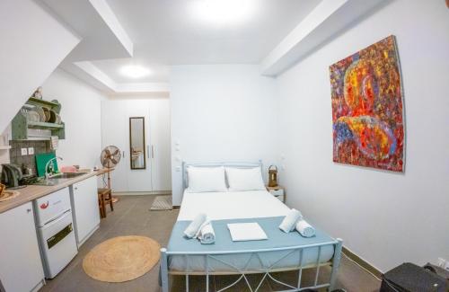 a bedroom with a bed and a painting on the wall at Kali Strata 1 - Downtown in Symi