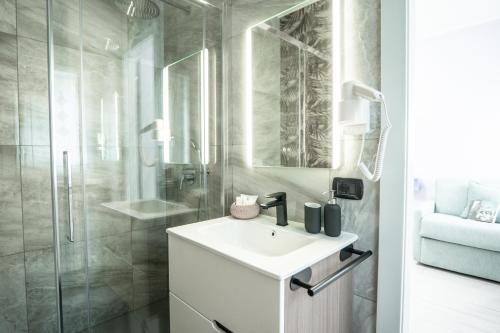 a white bathroom with a sink and a shower at Lario Panorama in Colico