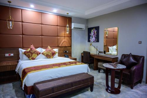 a hotel room with a large bed and a desk at Exclusive Serene Hotel Abuja in Abuja