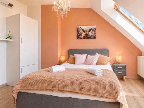 a bedroom with a large bed with an orange wall at 10-Min Walk to Hauptbahnhof, Cozy Private Rooms with AC, TV & WIFI in Vienna