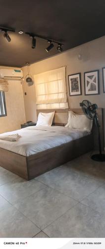 a bedroom with a large bed and a lamp at Stallion Luxury Suites Mararaba in Abuja