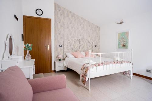 a bedroom with a white bed and a pink crib at Lario Panorama in Colico