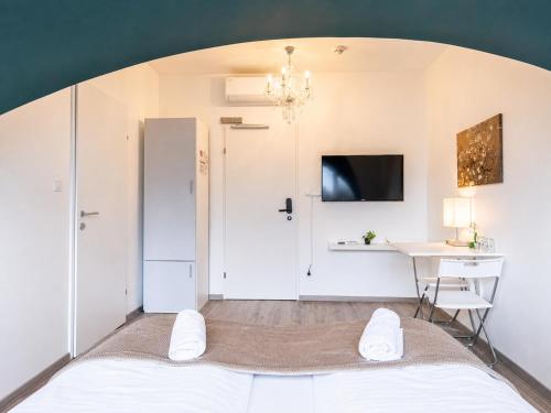 a room with a bed and a table and a desk at 10-Min Walk to Hauptbahnhof, Cozy Private Rooms with AC, TV & WIFI in Vienna