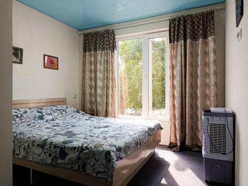 a bedroom with a bed and a window at Asian Guest House in Bishkek
