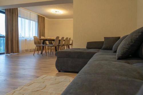 a living room with a couch and a table and chairs at Vila dintre Brazi in Râu de Mori
