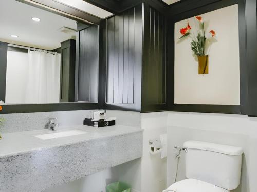 a bathroom with a toilet and a sink and a mirror at Sarita Chalet & Spa Jomtien beach Pattaya in Jomtien Beach