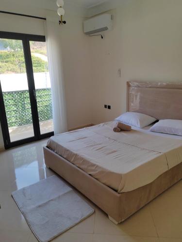 a large bed in a bedroom with a large window at Villa Lila in Cherchell
