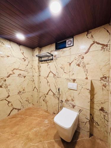 a bathroom with a toilet on a stone wall at Odyssey Rendezvous in Chottanikara