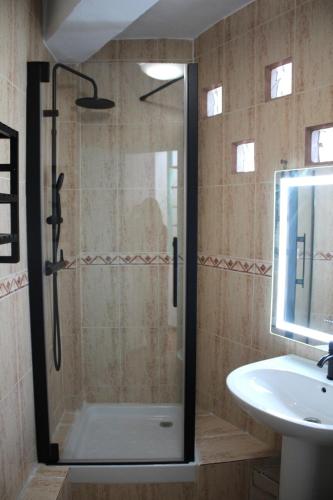 a shower with a glass door next to a sink at Casa Nido in Ríogordo