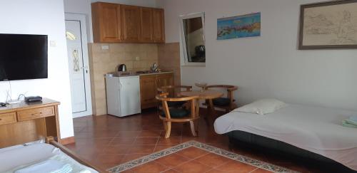 a bedroom with a bed and a kitchen with a table at Amore apartments in Budva