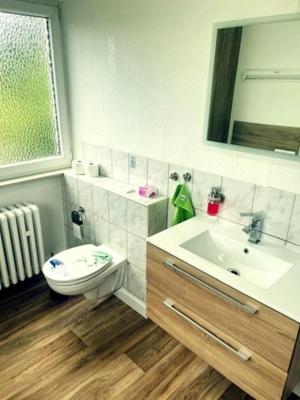 a bathroom with a sink and a toilet and a mirror at Pension am Schottenring in Schotten