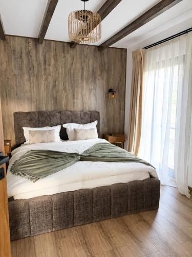 a bedroom with a large bed and a chandelier at SevenHeaven in Mărişel