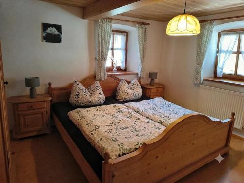 a bedroom with a wooden bed with pillows on it at Ferienhof Aiginger in Grafenau