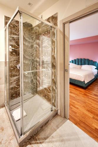 a glass shower in a room with a bed at Tao chambre in Taormina