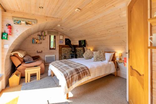 a bedroom in a tiny house with a bed and a couch at Finest Retreats - Idris Pod in St Asaph