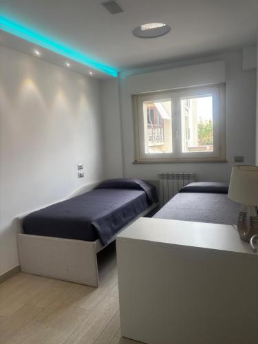 a bedroom with two beds and a blue light at Carducci Sunrise in Tortoreto Lido