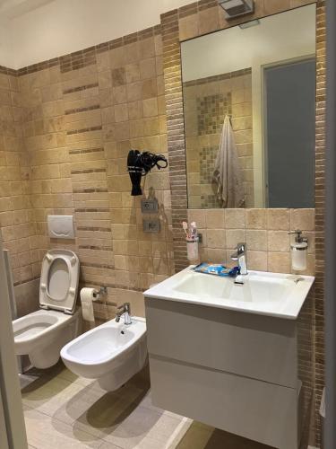 a bathroom with a sink and a toilet and a mirror at Carducci Sunrise in Tortoreto Lido