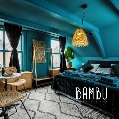 a blue bedroom with a bed and a chandelier at Bambu Kitchen & Bar - Hotel Restaurant in Haarlem