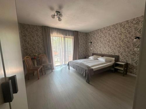 ein Schlafzimmer mit einem Bett und einem Fenster in der Unterkunft Maison Platanus in Voineasa