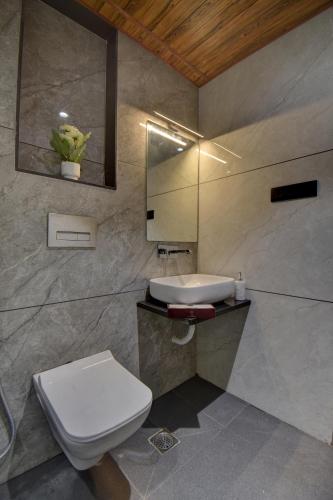 a bathroom with a toilet and a sink at Hotel Sai Mahima, Near Sai Baba Temple in Shirdi