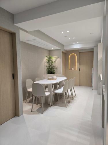 a dining room with a white table and chairs at 더하다 in Busan