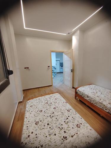 a bedroom with a bed and a rug on a wooden floor at Villa zahra 7 in Kêf Bisnês