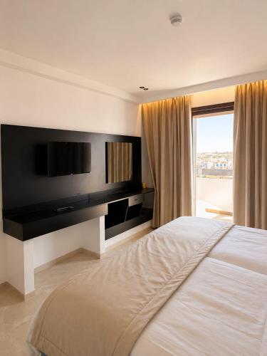 a bedroom with a large bed and a large window at HOTEL KAISER in Sousse