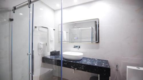 a bathroom with a sink and a shower at Exclusive Serene Hotel Abuja in Abuja